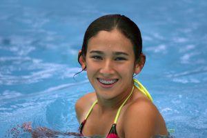 young girl with braces in pool 