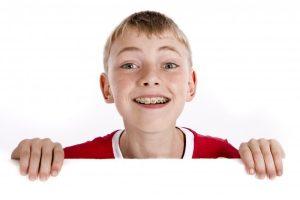young boy in red shirt with early braces 