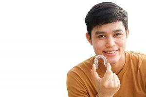young man holding Invisalign tray