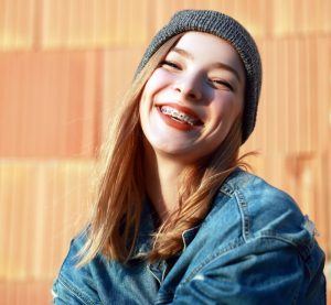 young woman with braces wearing beanie