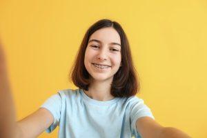young girl with braces taking a selfie