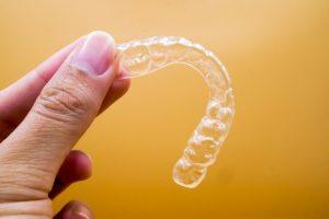 hand holding an Invisalign tray