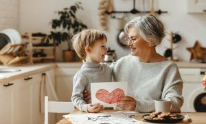 young child sitting at table with grandmother