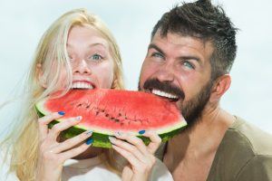 man and woman eating a watermelon