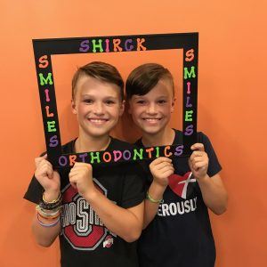 adorable young boys holding a Shirck Orthodontics sign 