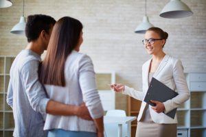 female realtor talking to couple in house