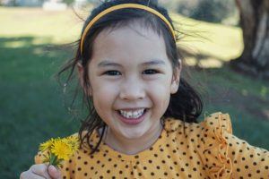 young girl with slightly crooked teeth outside