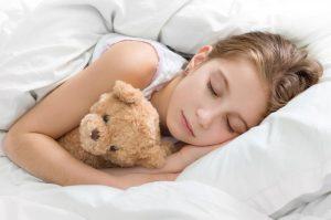 young girl sleeping with teddy bear 