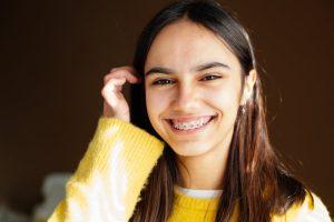 smiling teen girl with traditional braces 
